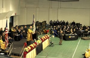 Board of Governor Patrick Ford is shown at the podium, greeting graduates and guests.