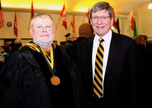 From left, retiring professor Dr. Dave Thomas and President Stephen Greiner greet each other at commencement.