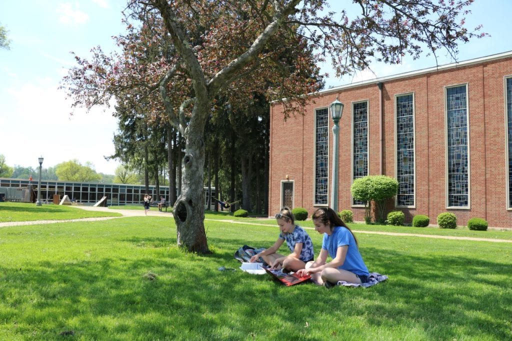 Students under tree and chapel